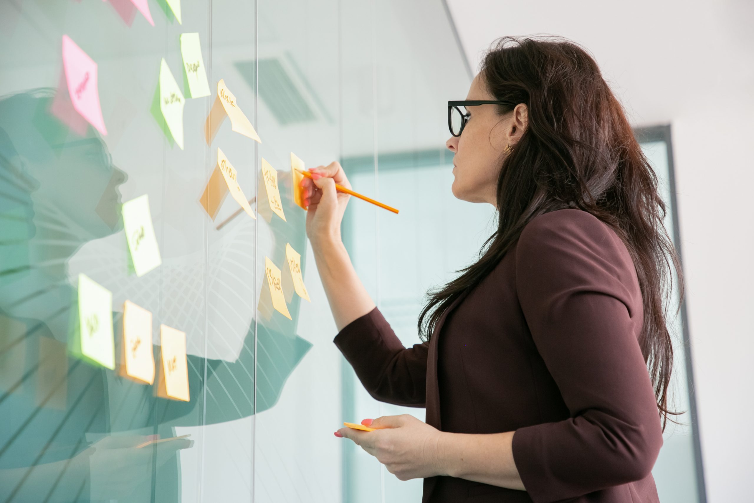Foco nos estudos: mulher de óculos escrevendo em post it .
