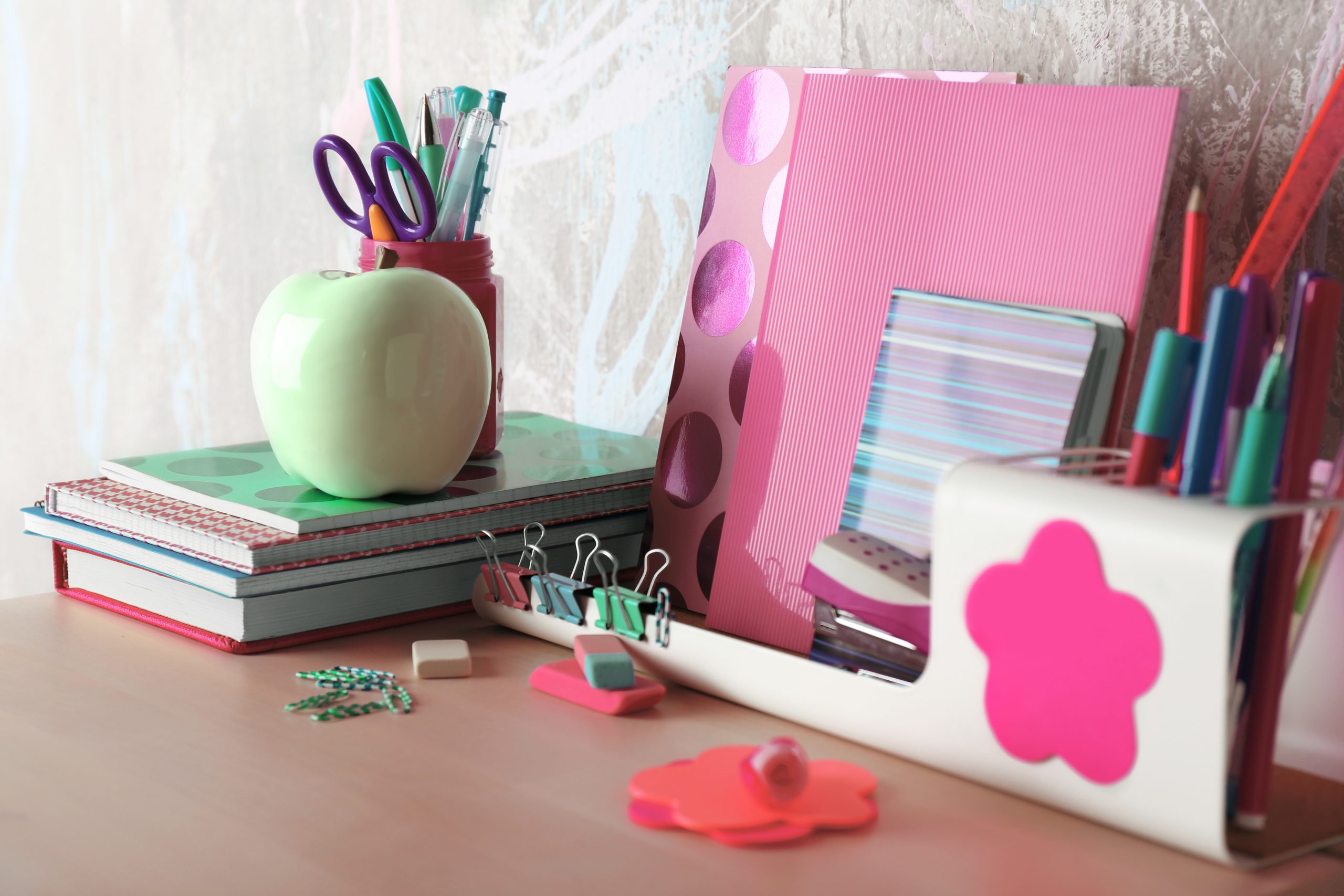 Mesa de estudos arrumada com livros, cadernos e canetas.