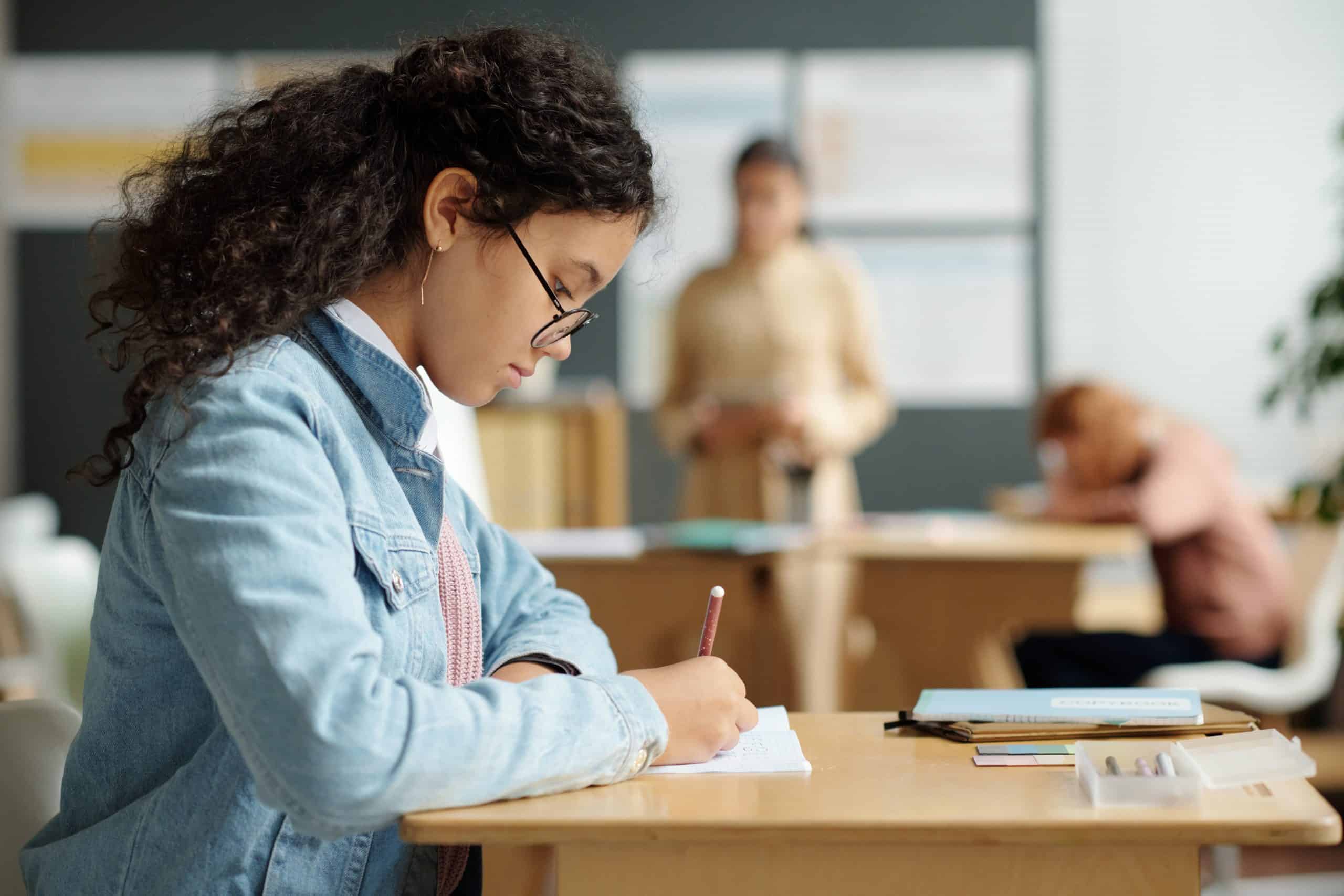 Mulher sentada em uma mesa estudando.