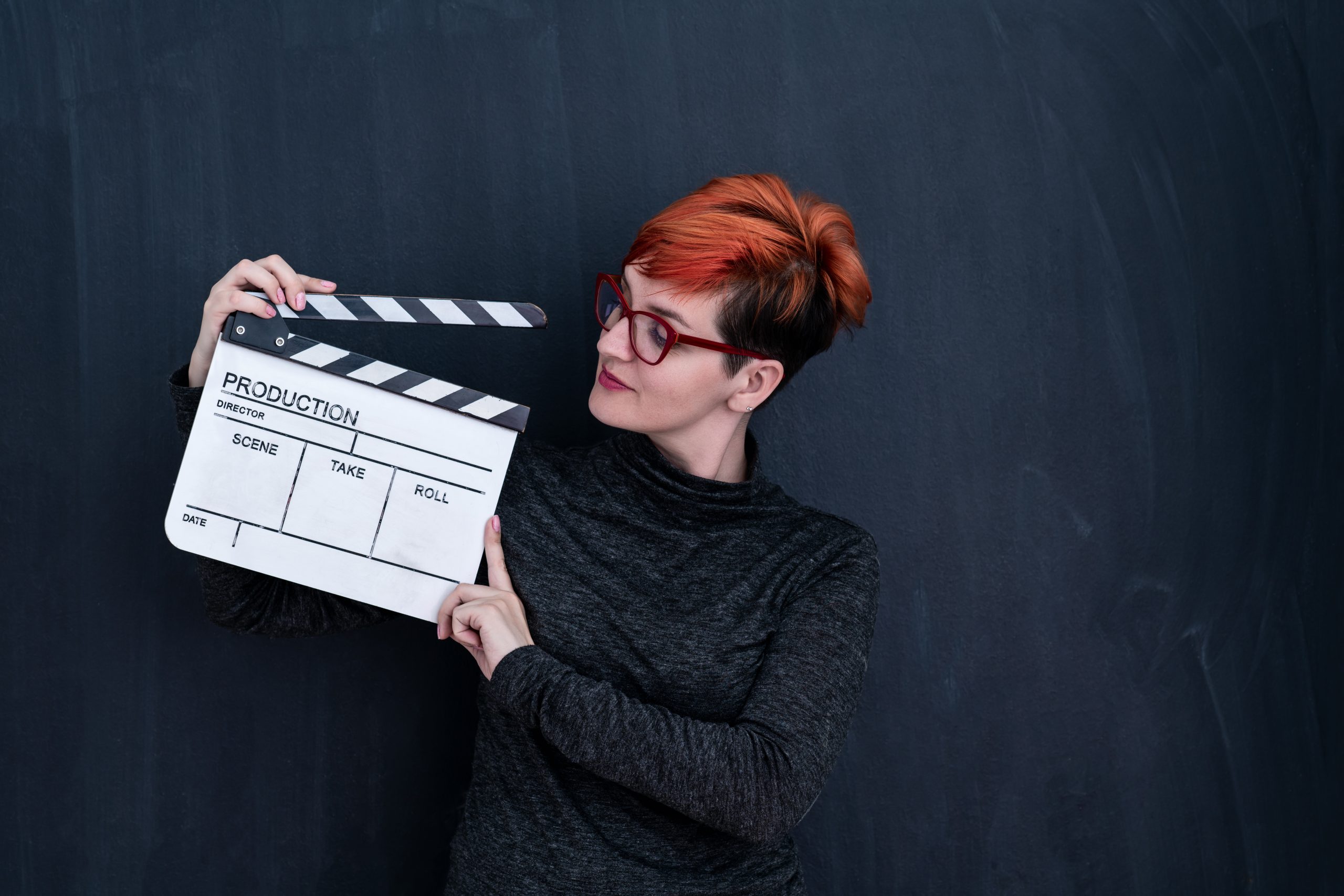 Mulher segurando uma claquete de cinema.