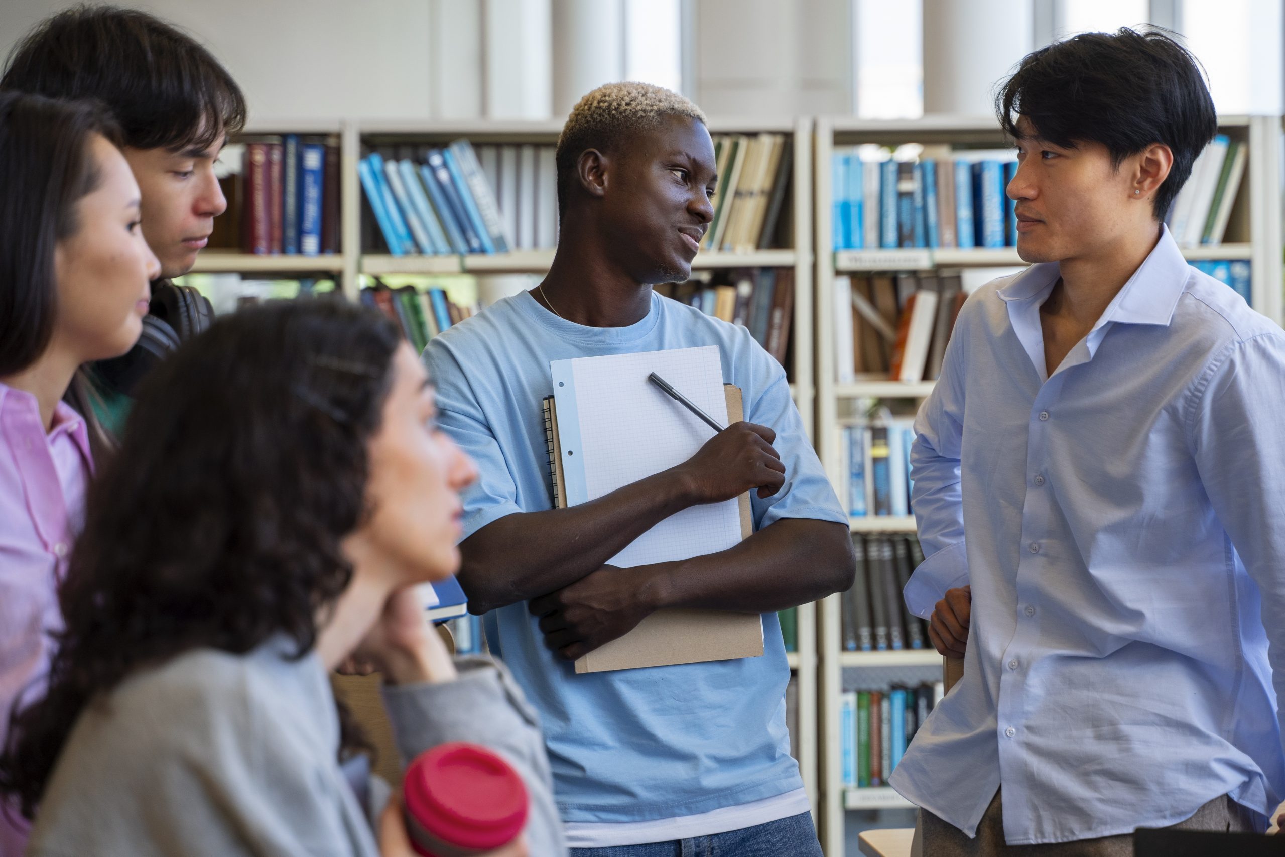 Vários alunos conversando em uma biblioteca