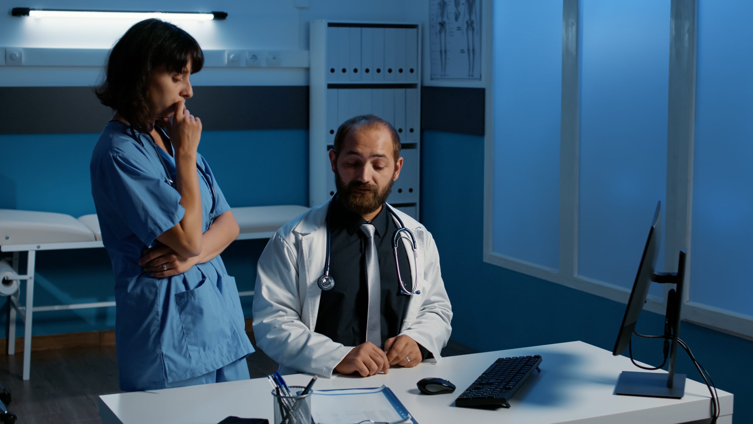 Médico e enfermeira conversando em um escritório médico.