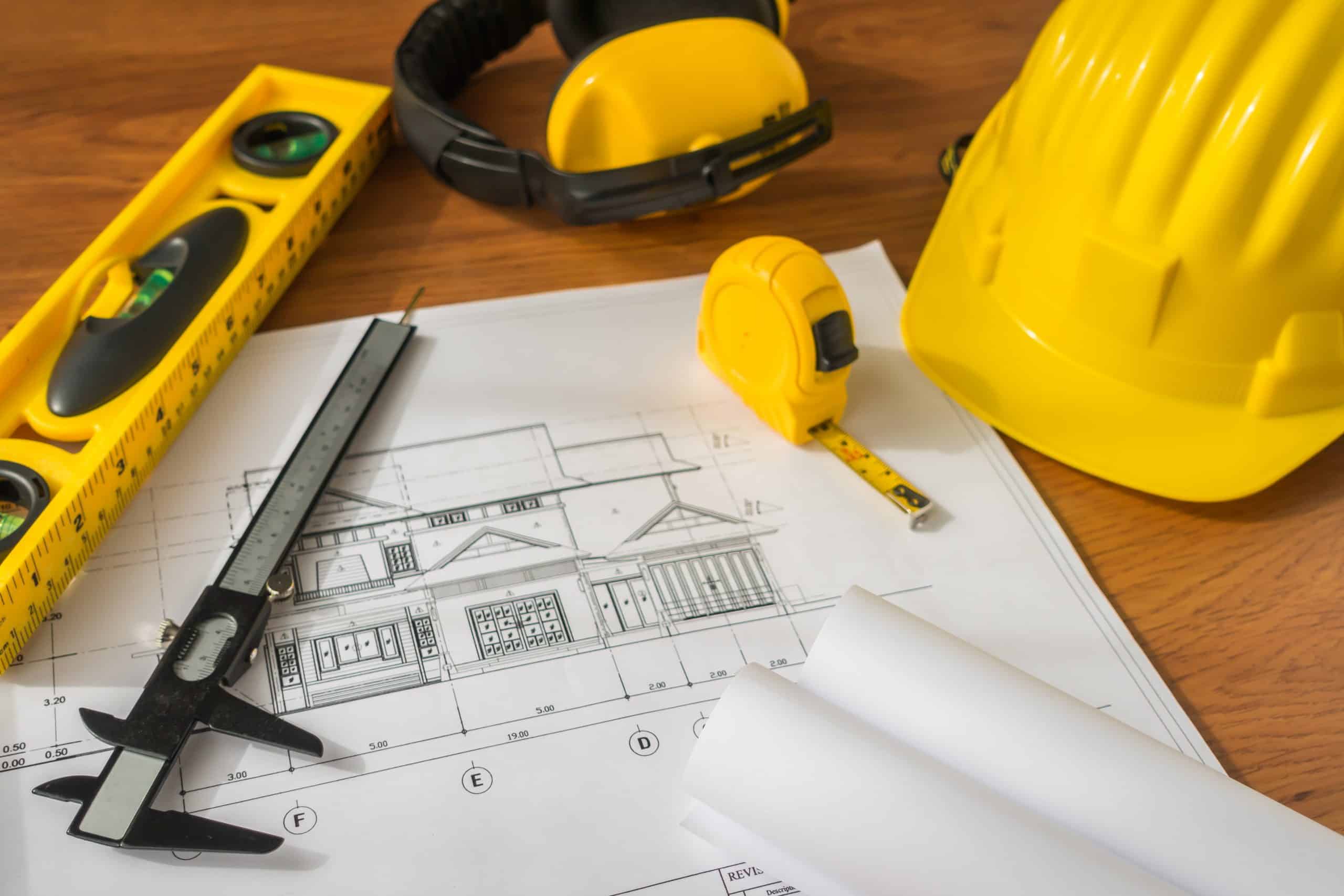 Vários itens de um engenheiro civil em cima de uma mesa