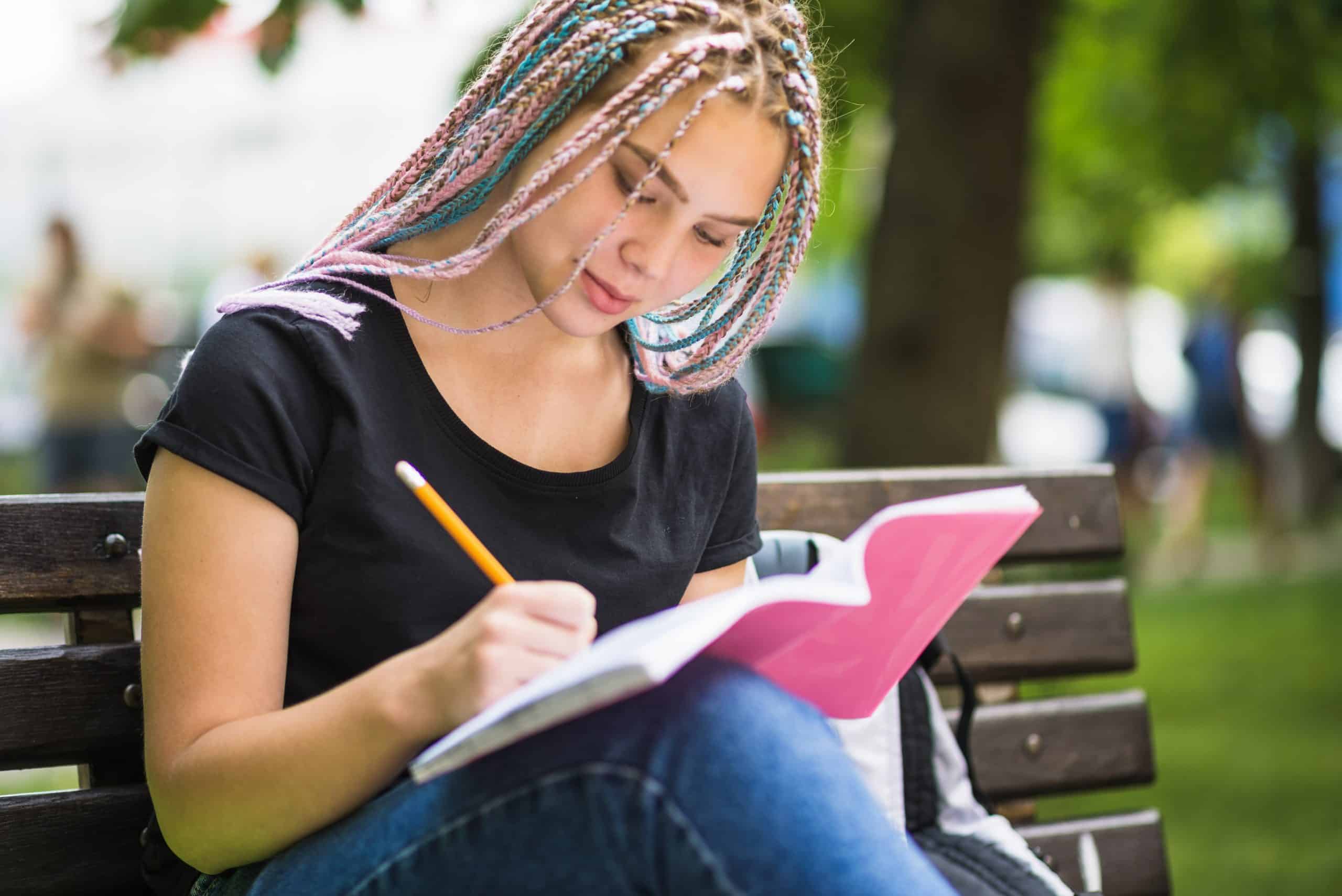 Estudante escrevendo em um caderno