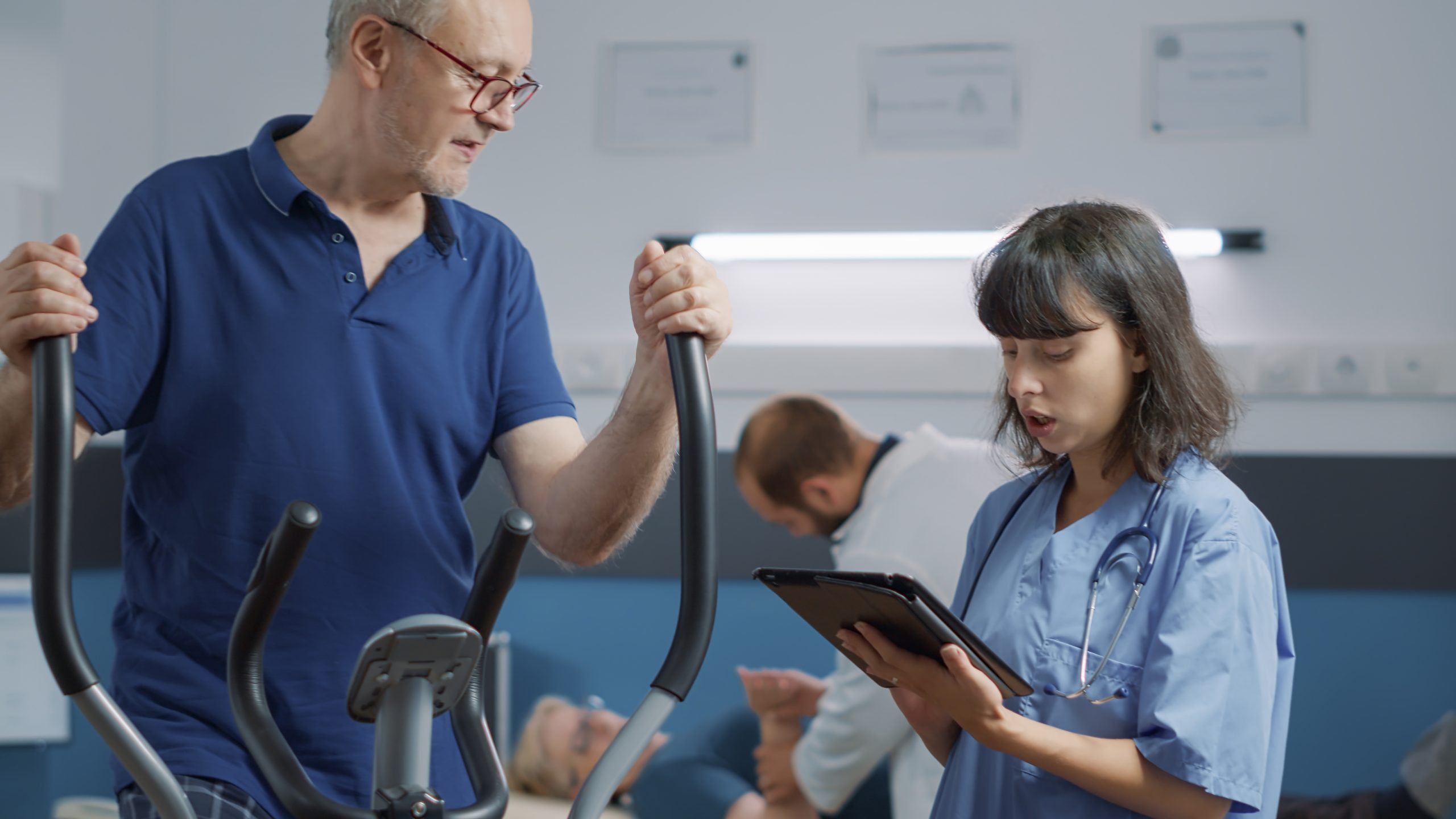 Idoso se exercitando acompanhado de uma médica.