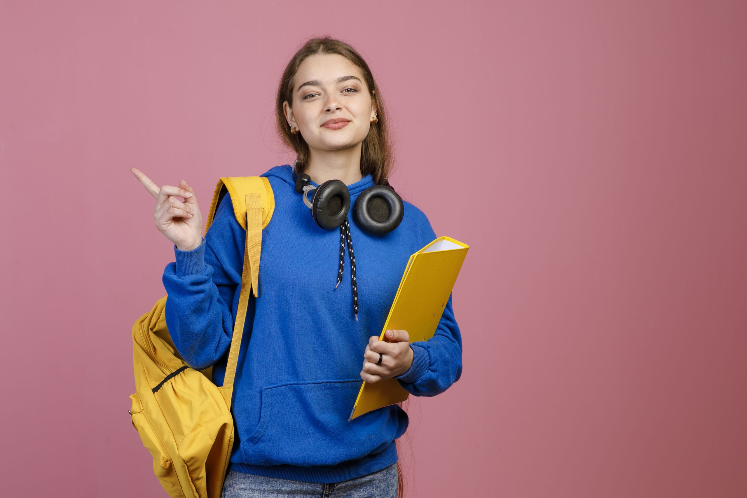 Jovem estudante em pé, segurando um caderno