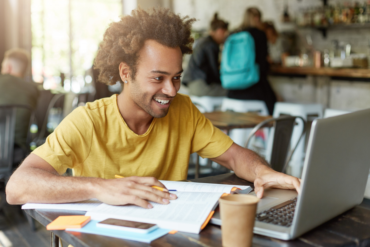 Estudante em uma cafeteria fazendo algumas anotações