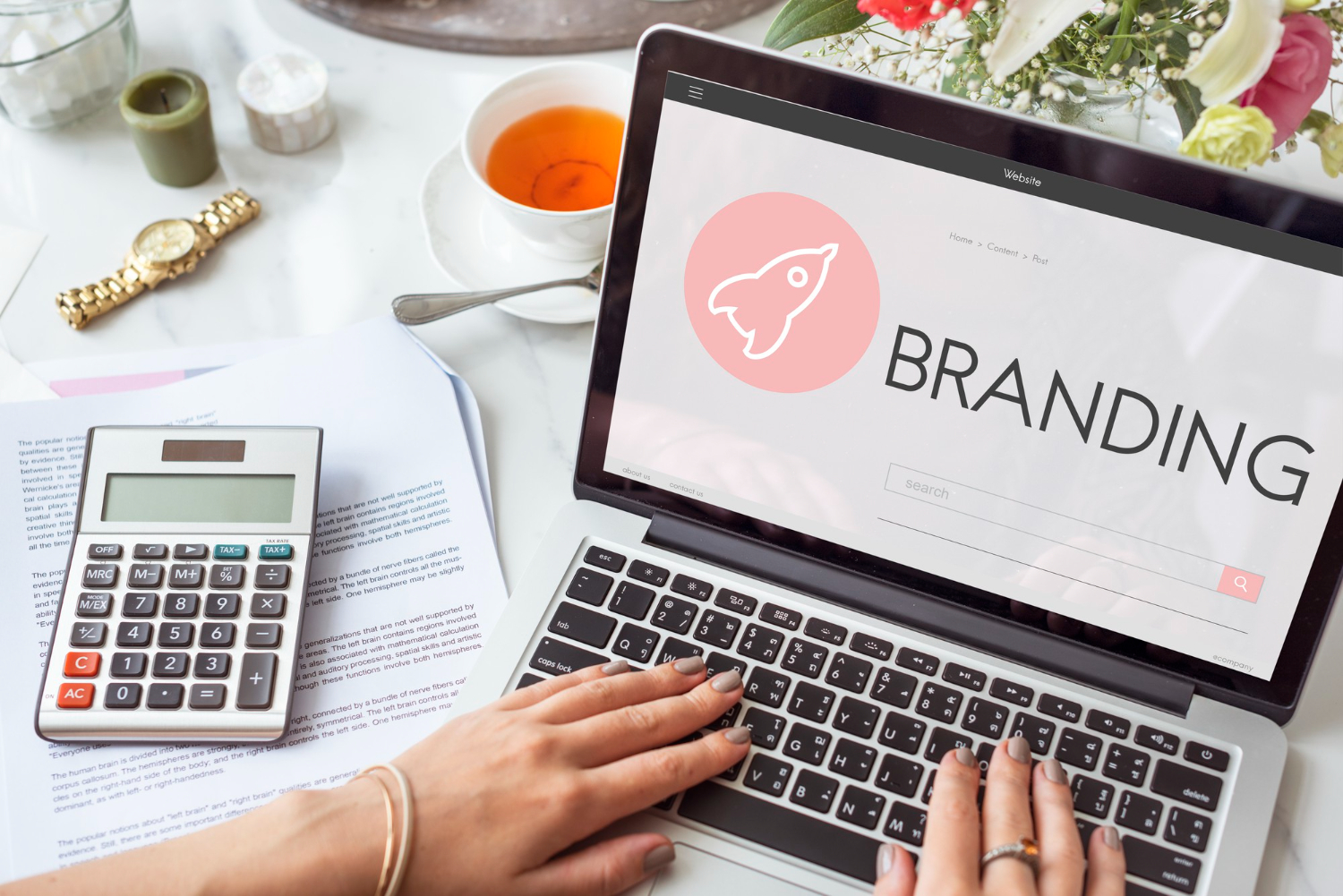 Mãos femininas mexendo em um notebook aprendendo sobre o que é branding